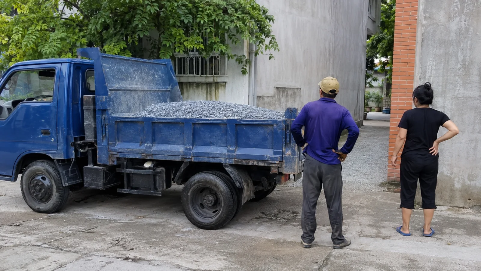 Xe giao đá xây dựng và điểm nhận hàng trước hẻm nhỏ