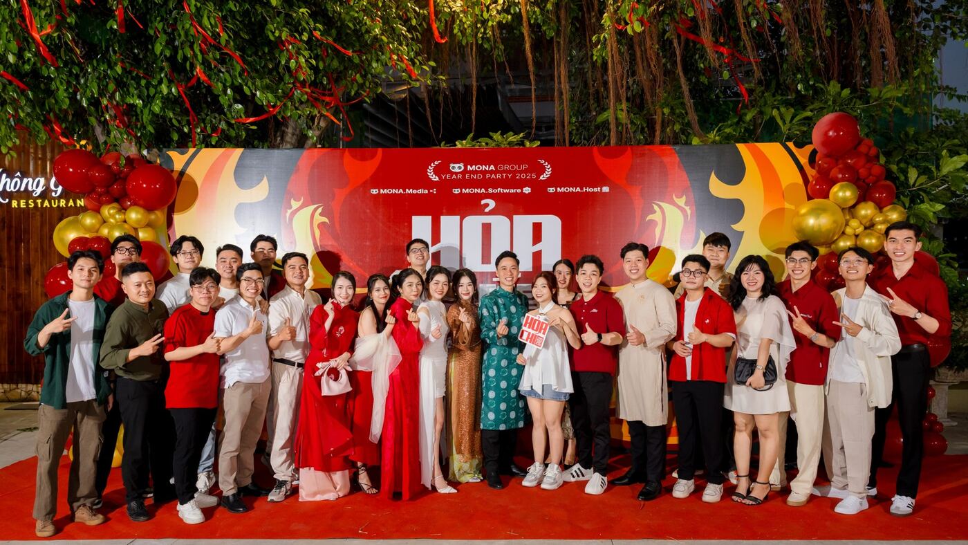 Đội ngũ MONA chụp ảnh tập thể trước phông tiệc tất niên cuối năm